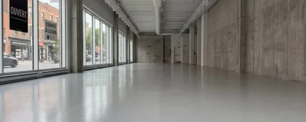 Intérieur d'une boutique commerciale moderne à Montréal avec un plancher époxy réfléchissant la lumière naturelle des vitrines