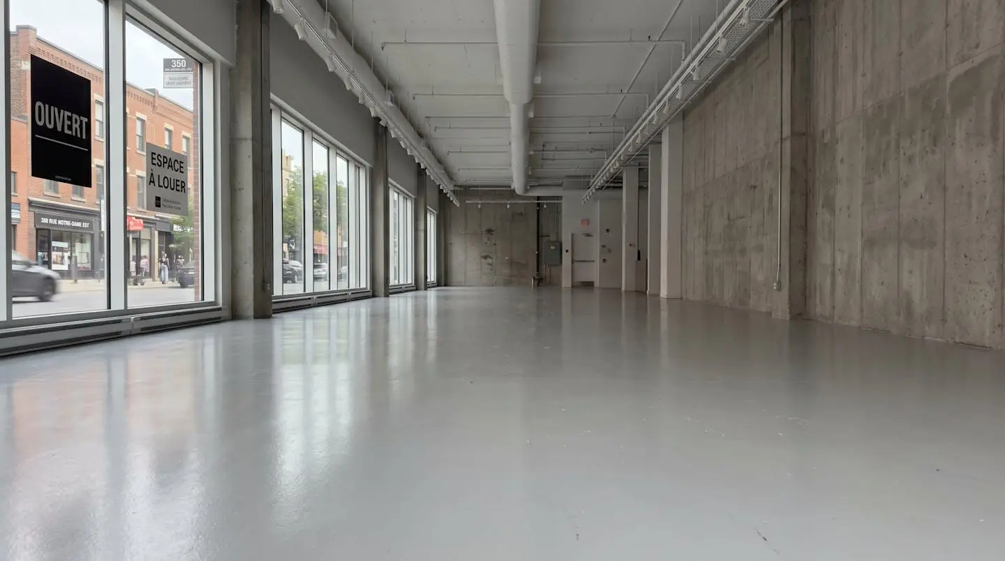 Intérieur d'une boutique commerciale moderne à Montréal avec un plancher époxy réfléchissant la lumière naturelle des vitrines